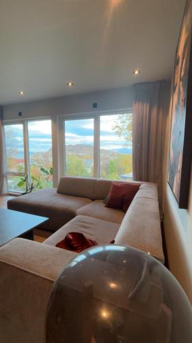 a living room with a couch and a large window at House with parking and view in Harstad