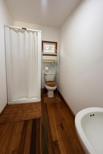 a bathroom with a toilet with a shower and a sink at Lily's Sunrise Villa in Ladyville