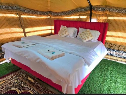 a bedroom with a bed with towels on it at Star line for Desert Camping in Bidiyah