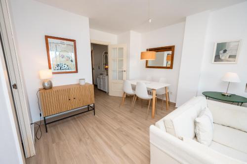 Una sala de estar con un sofá blanco y una mesa. en Rincón de la Caleta, en La Herradura