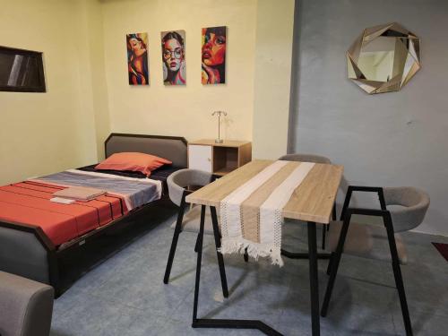 Un dormitorio con una cama y una mesa y sillas. en The Baluarte, en Maasin