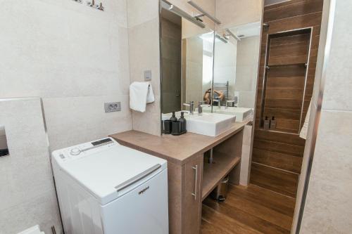 Un baño con lavabo y lavadora. en St Marks boutique apartament, en Zagreb