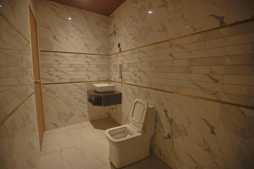 a bathroom with a toilet and a sink at Hotel Om Vilas in Jait