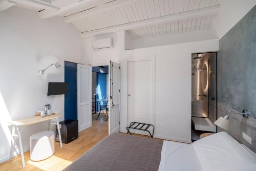 Un dormitorio blanco con una cama y un escritorio. en Le Stanze di Triyah, en Palermo