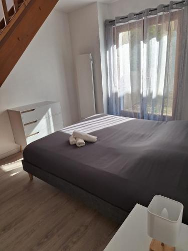 a bedroom with a bed with two slippers on it at AquaLodge Vitalia in Aix-les-Bains