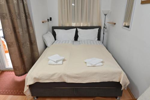 a bedroom with a large bed with two towels on it at Apartman Dora in Vinkovci