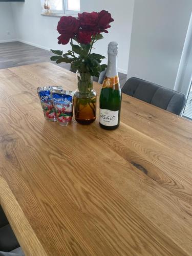 a bottle of beer and flowers on a wooden table at U Fera in Stará Bystrica