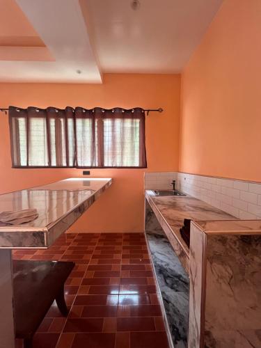 una cocina con paredes naranjas y encimeras de mármol en Paypay Resthouse, en San Francisco