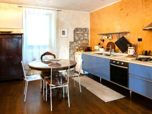 a kitchen with blue cabinets and a table and a sink at From the city to nature Mezzane di sotto VR pet-friendly in Postuman