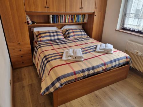 una camera da letto con un letto con le scarpe sopra di La Casa degli Sbilfs - Wi-Fi, Netflix e Garage Box , a 2 minuti dallo Zoncolan a Ravascletto