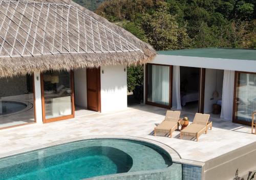 a villa with a swimming pool and a house at SABA Lombok in Selong Belanak