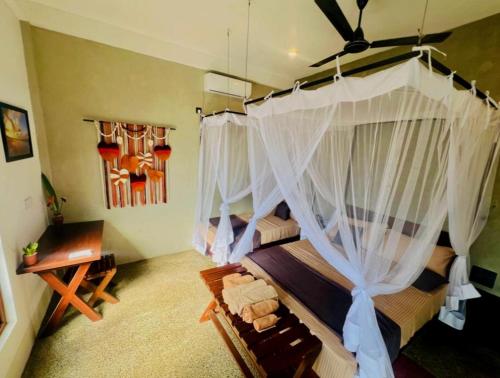 a bedroom with a large canopy bed with curtains at Surface Stay and Café in Tangalle