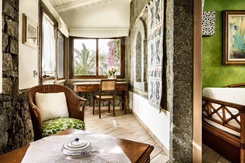 a room with green walls and a table and chairs at Hotel Stella Maris in Villasimius