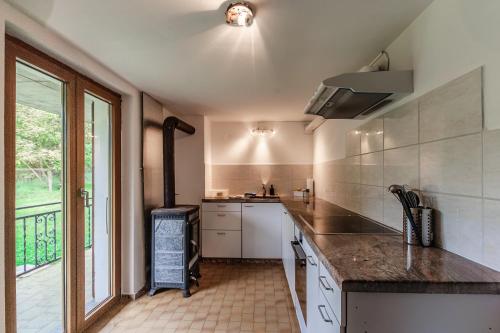 a kitchen with a counter and a large window at Eco della Valle Apartments by Quokka 360 - with views of the surrounding mountains in Faido