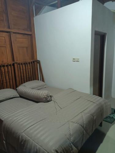 Un pat sau paturi într-o cameră la Villa Ndalem Pendowoharjo Jogja