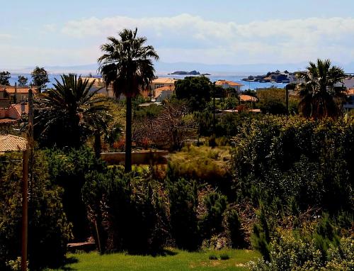 a view of a garden with palm trees and the ocean at Grand Villa Nefeli - Private Spa in Lagonissi