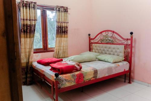 a small bed in a room with a window at LovKend in Ruteng