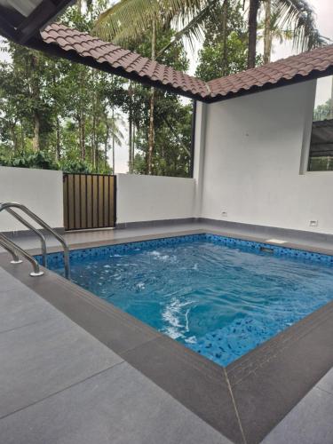a large swimming pool with blue water at Cabana banasura Wayanad 2bhk in Padinjarathara