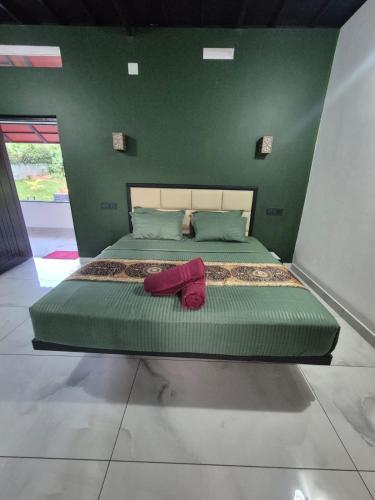 a bedroom with a large bed with green walls at Cabana banasura Wayanad 2bhk in Padinjarathara