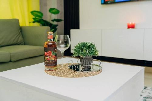 a bottle of wine and a glass on a table at One Apartment in Gaborone