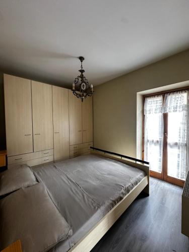 Un dormitorio con una cama grande y una lámpara de araña. en Chalet Piazzi, en Semogo