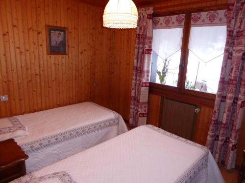 une chambre avec deux lits et une fenêtre dans l'établissement Covagnet RDC, à La Clusaz