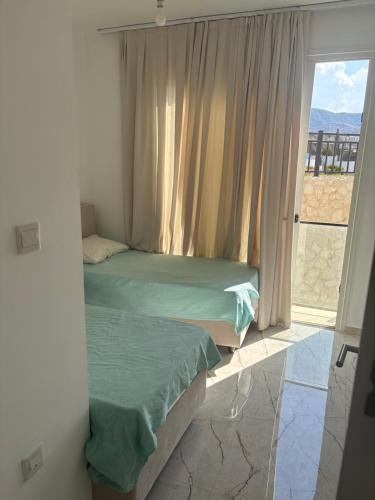 Dos camas sentadas en una habitación con ventana. en Poseidon North Ciprus, Tatlisu, 