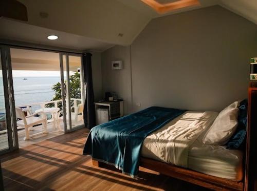 a bedroom with a bed with a view of the ocean at Kohtao Hillside resort in Koh Tao