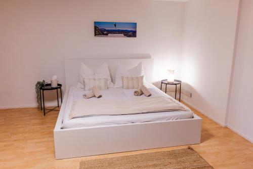 a white bed in a white bedroom with two tables at Skier‘s Lodge - Best View in Town! in Sankt Egidi
