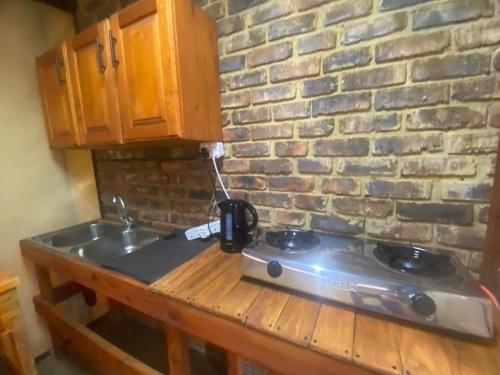 encimera de cocina con fogones y pared de ladrillo en Vlakvark Tented Camp, en Bela-Bela
