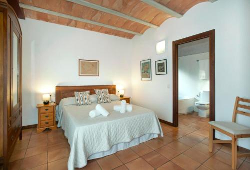 ein Schlafzimmer mit einem weißen Bett und ein Badezimmer in der Unterkunft La Casa en el Pinar by Vintage Travel in Biniancolla