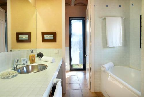 ein Badezimmer mit Waschbecken und Badewanne in der Unterkunft La Casa en el Pinar by Vintage Travel in Biniancolla