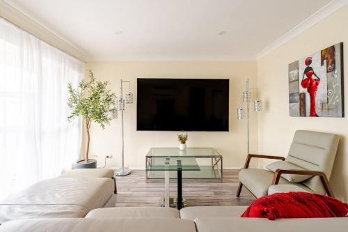 Μια τηλεόραση ή/και κέντρο ψυχαγωγίας στο Cheerful 4 bedroom home with parking on premises