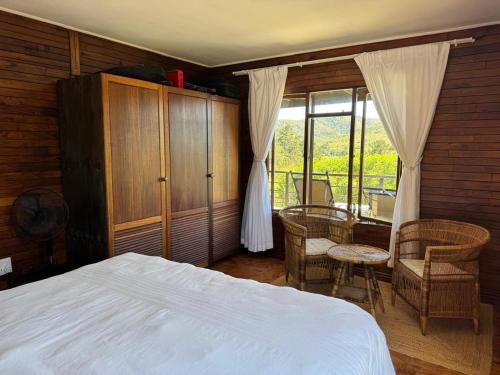 a bedroom with a bed and a table and chairs at Howberry Hills in Plettenberg Bay