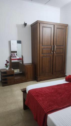 a bedroom with a bed and a dresser and a mirror at Sapphire Homestay in Dehiwala