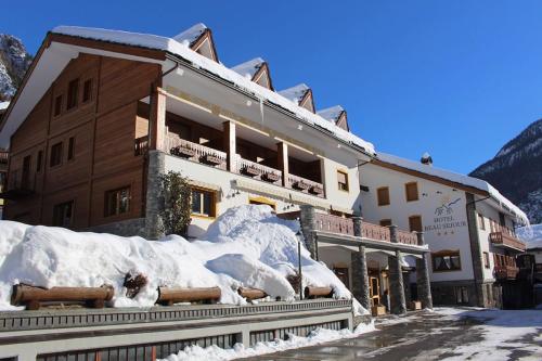a large building with snow on the side of it at Hotel Beau Sejour Pré-Saint-Didier in Pré-Saint-Didier