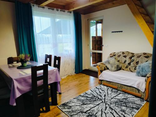 a living room with a couch and a table at Chata z Pary in Prącki