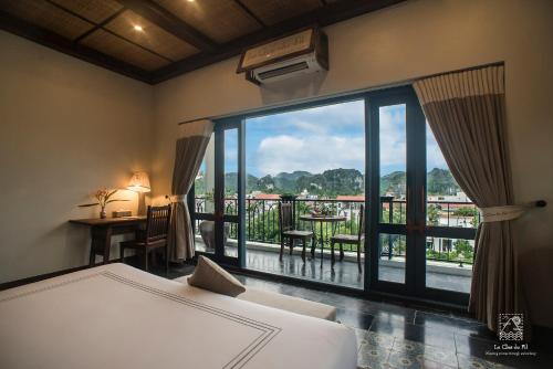 a bedroom with a bed and a view of a balcony at Le Clos Du Fil in Ninh Binh