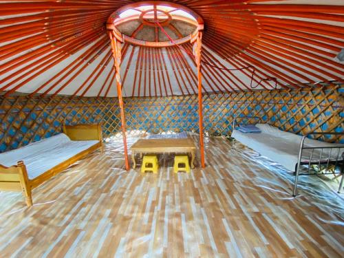 a room with two beds and a table in a yurt at Yurt and Mongolian Ger in Arhust