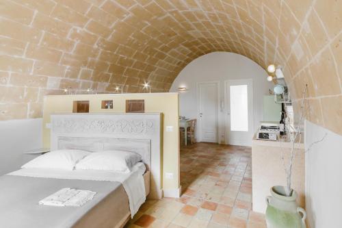 マテーラにあるLa Casa di Gianniのレンガの壁、ベッド付きのベッドルーム1室