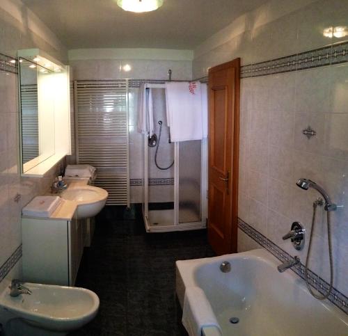 La salle de bains est pourvue de 2 lavabos, d'une baignoire et d'une douche. dans l'établissement Casa Guido e Laura, à Pozza di Fassa