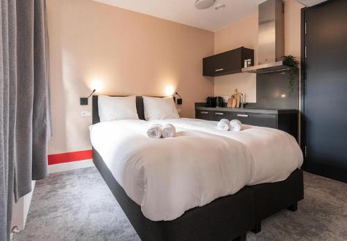 a bedroom with a large bed with towels on it at Central Tilburg Apartments in Tilburg