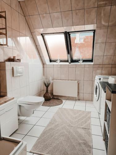 a bathroom with a toilet and a sink and a window at Modern wohnen, nahe Steinhuder Meer in Hagenburg
