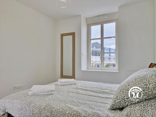 une chambre blanche avec un lit et un miroir dans l'établissement Gîte Le 47, 6 à 8 personnes, à Louverné