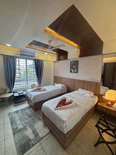 a hotel room with two beds in a room at Reva suites in Arsikere