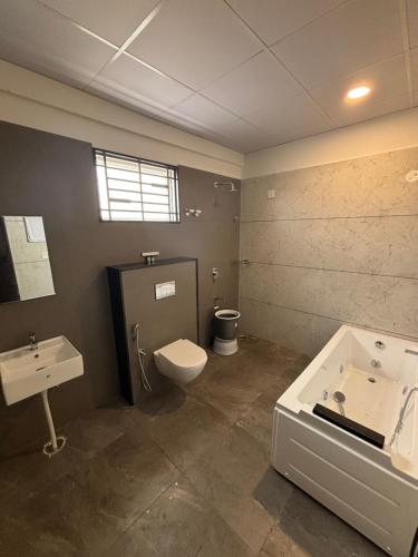 a bathroom with a toilet and a sink at Reva suites in Arsikere