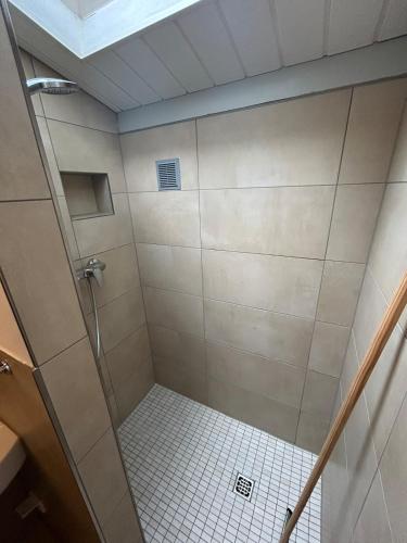 a bathroom with a shower with white tile at Bungalow Het Grootslag in Andijk