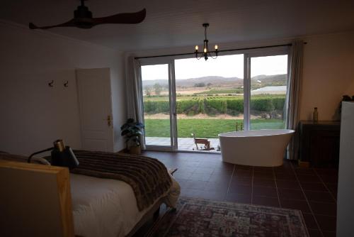 une chambre avec un lit, une baignoire et une fenêtre dans l'établissement Casa Del Sol Cottage, à McGregor
