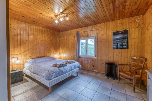 DomèneにあるAppartamento In Chaletの木製の部屋にベッド1台が備わるベッドルーム1室があります。