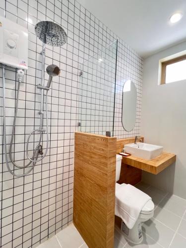 een badkamer met een douche, een toilet en een wastafel bij เดอะริม รีสอร์ท The Rim Resort in Ban Muang